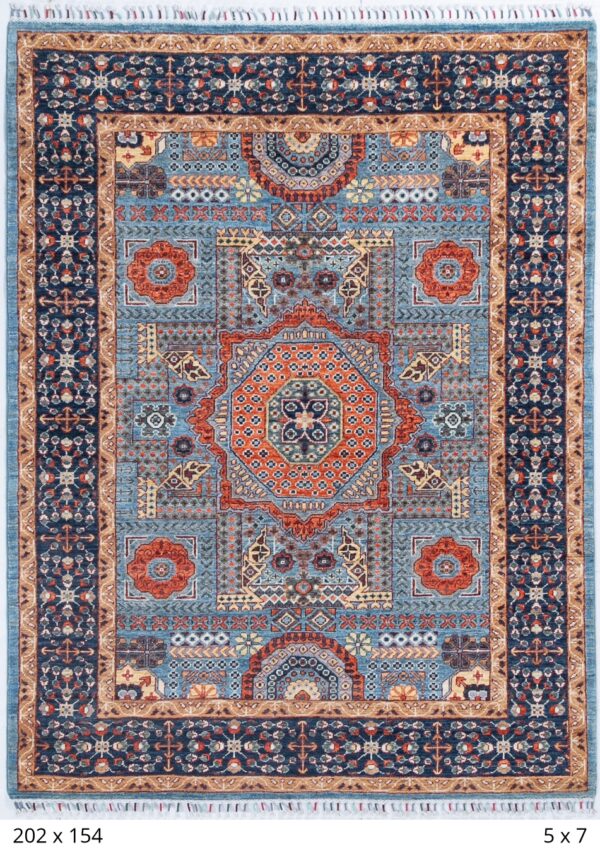 A beautiful handmade Mamluk Chobbi rug with light blue ground and a large geometric medallion with orange accents.